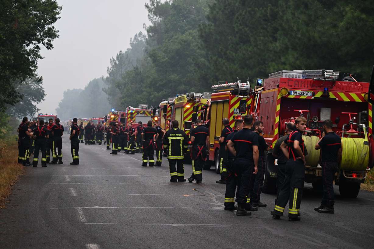 Firefighters wait on a road near Lacanau, southwestern France, on Saturday.