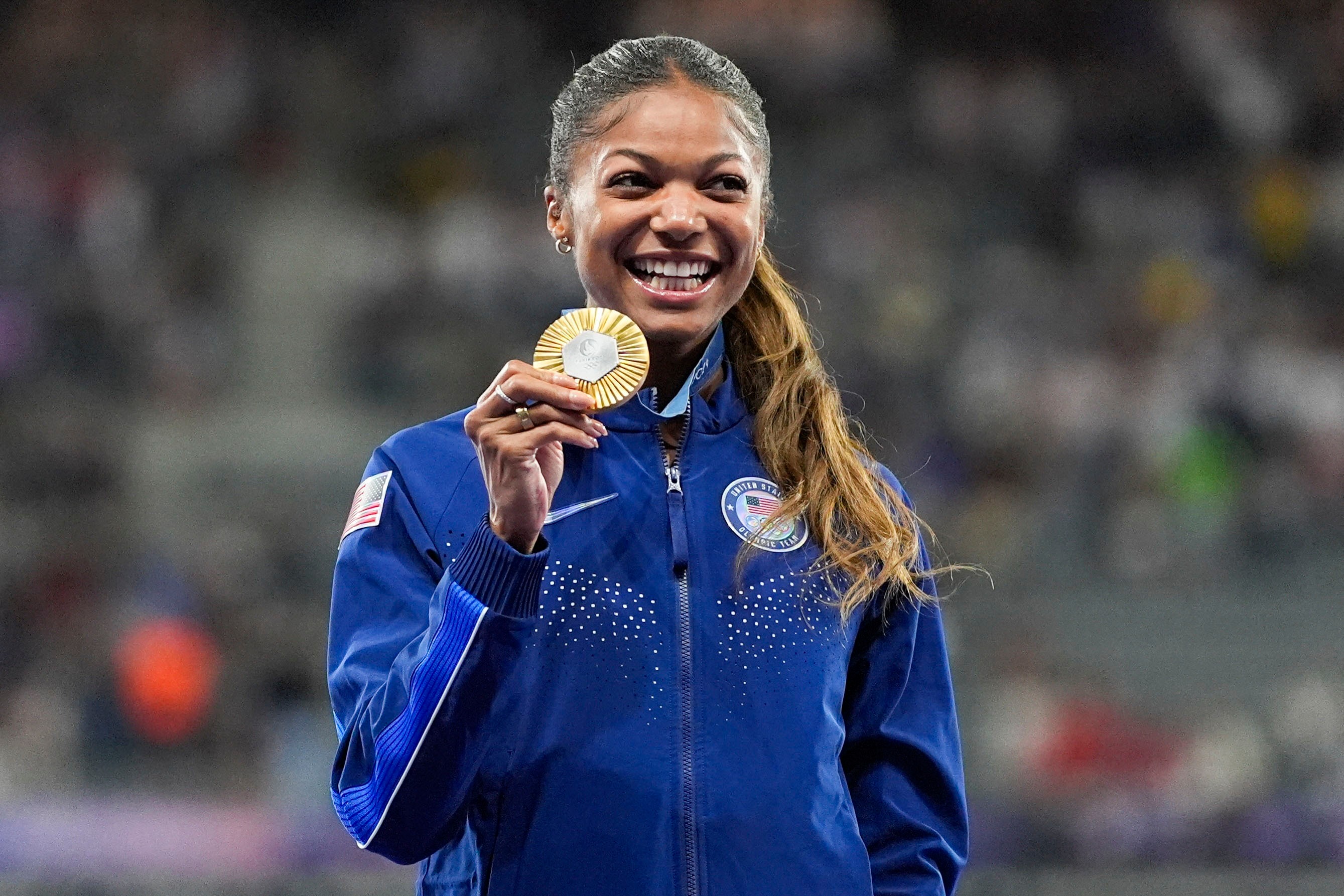 FILE - Gold medalist Gabby Thomas stands on the podium after the women's 200-meter at the 2024 Summer Olympics, Wednesday, Aug. 7, 2024, in Saint-Denis, France. 