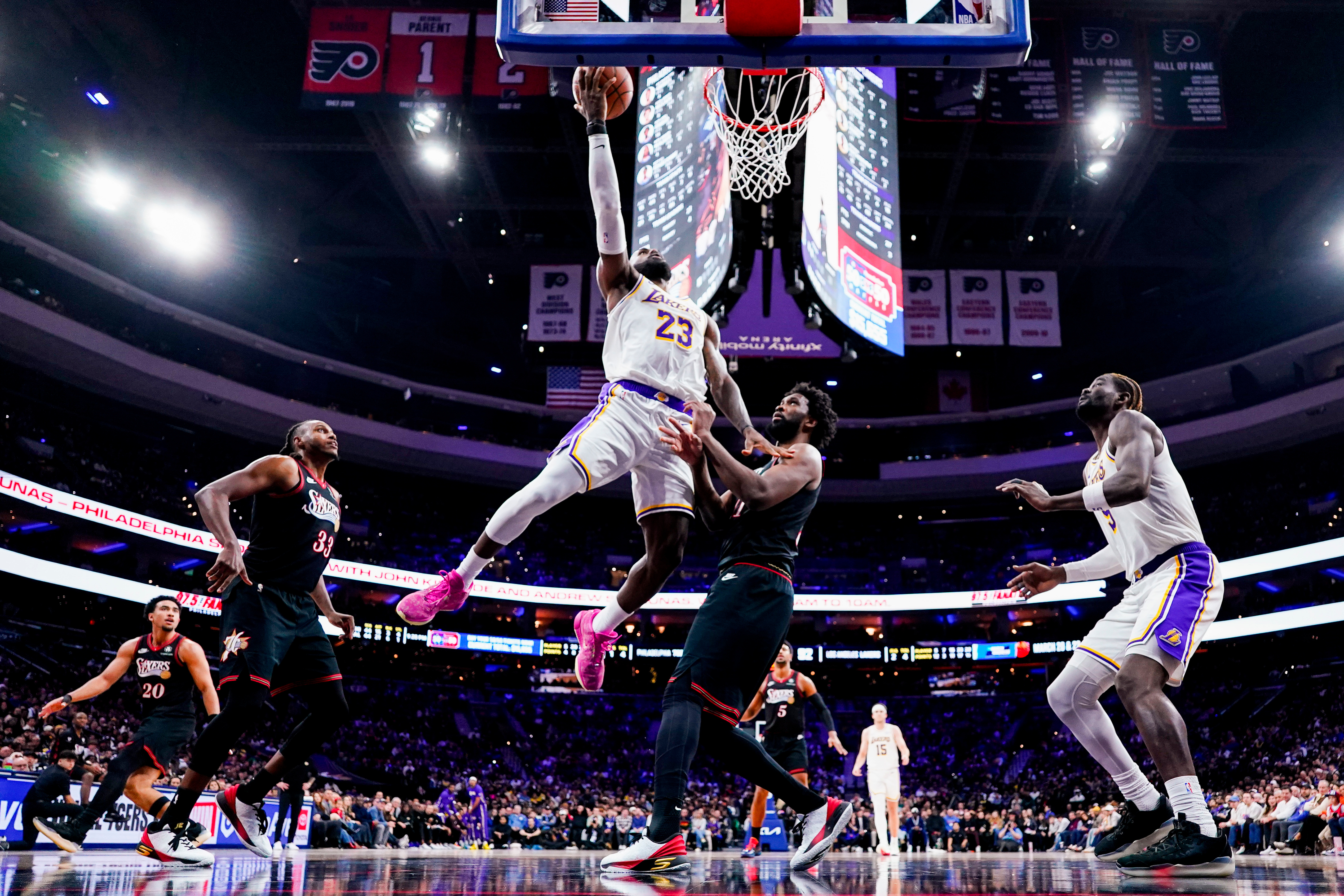 FILE - Los Angeles Lakers' LeBron James, center left, goes up for the shot against Philadelphia 76ers' Joel Embiid, center right, during the second half of an NBA basketball game, Dec. 7, 2025, in Philadelphia. 