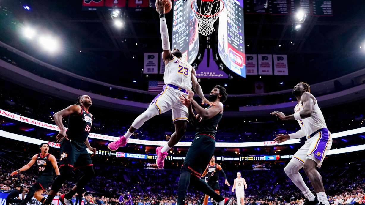FILE - Los Angeles Lakers' LeBron James, center left, goes up for the shot against Philadelphia 76ers' Joel Embiid, center right, during the second half of an NBA basketball game, Dec. 7, 2025, in Philadelphia.