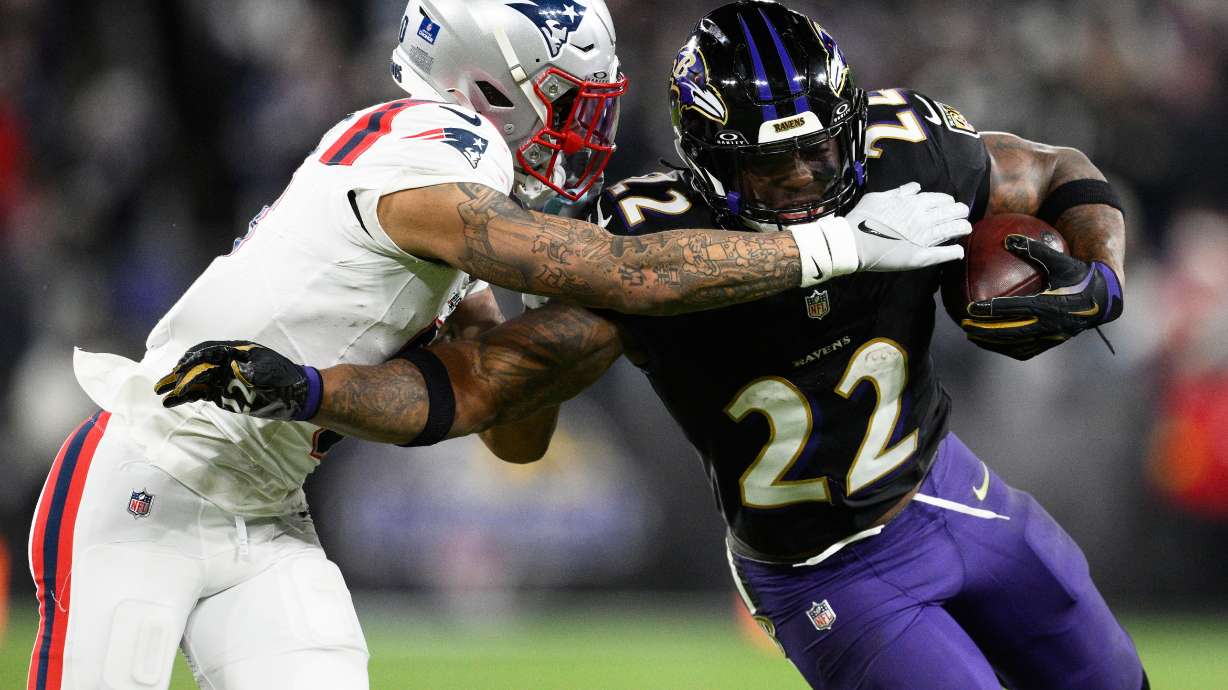FILE - Baltimore Ravens running back Derrick Henry (22) runs against New England Patriots cornerback Christian Gonzalez during the second half of an NFL football game, Dec. 21, 2025, in Baltimore.