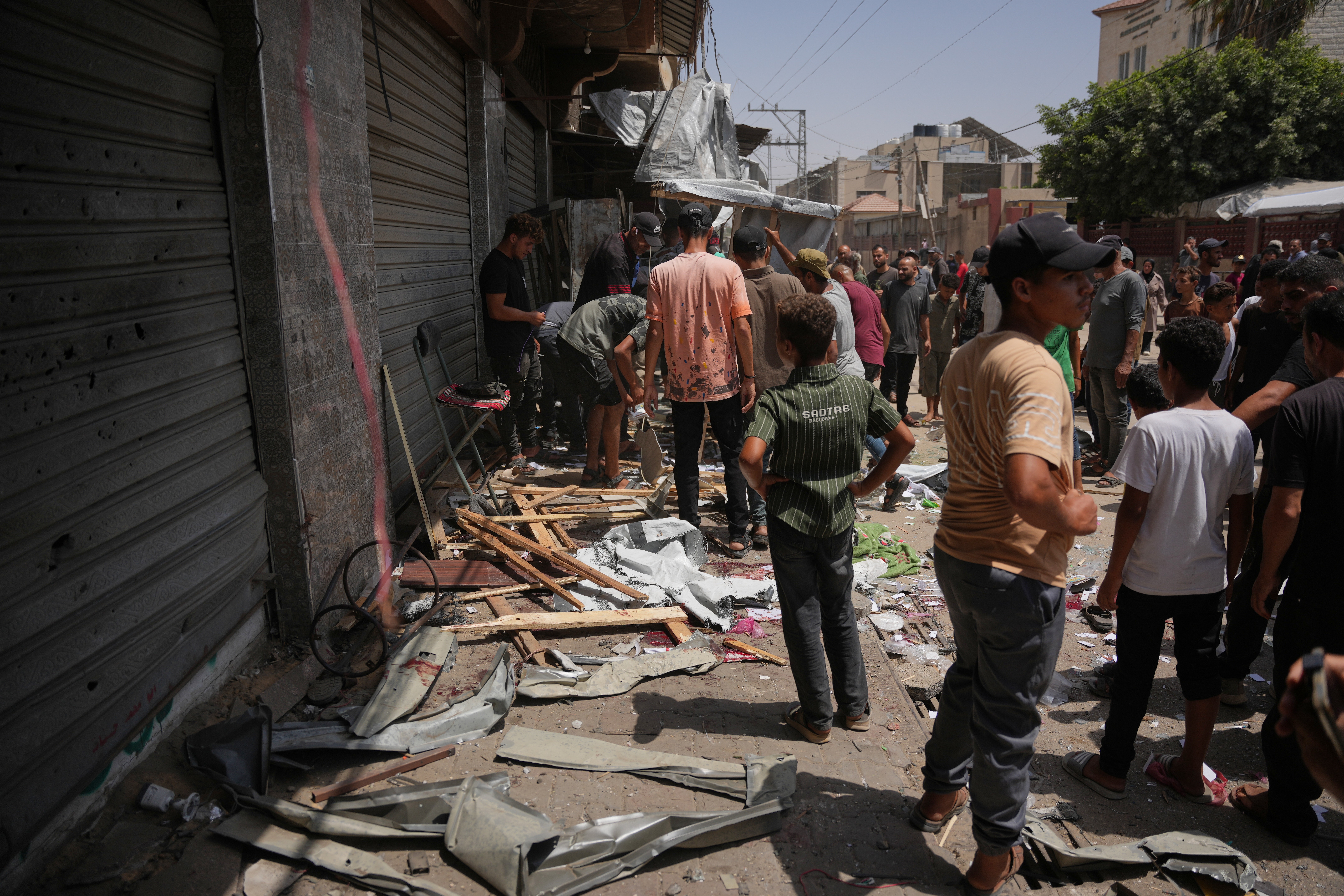 Palestinians inspect the site of an Israeli military strike, in Deir al-Balah, central Gaza Strip, Saturday. Israel's security cabinet on Sunday green-lit a proposal to allow an international stabilization force to enter the strip as part of a ceasefire deal struck in October.