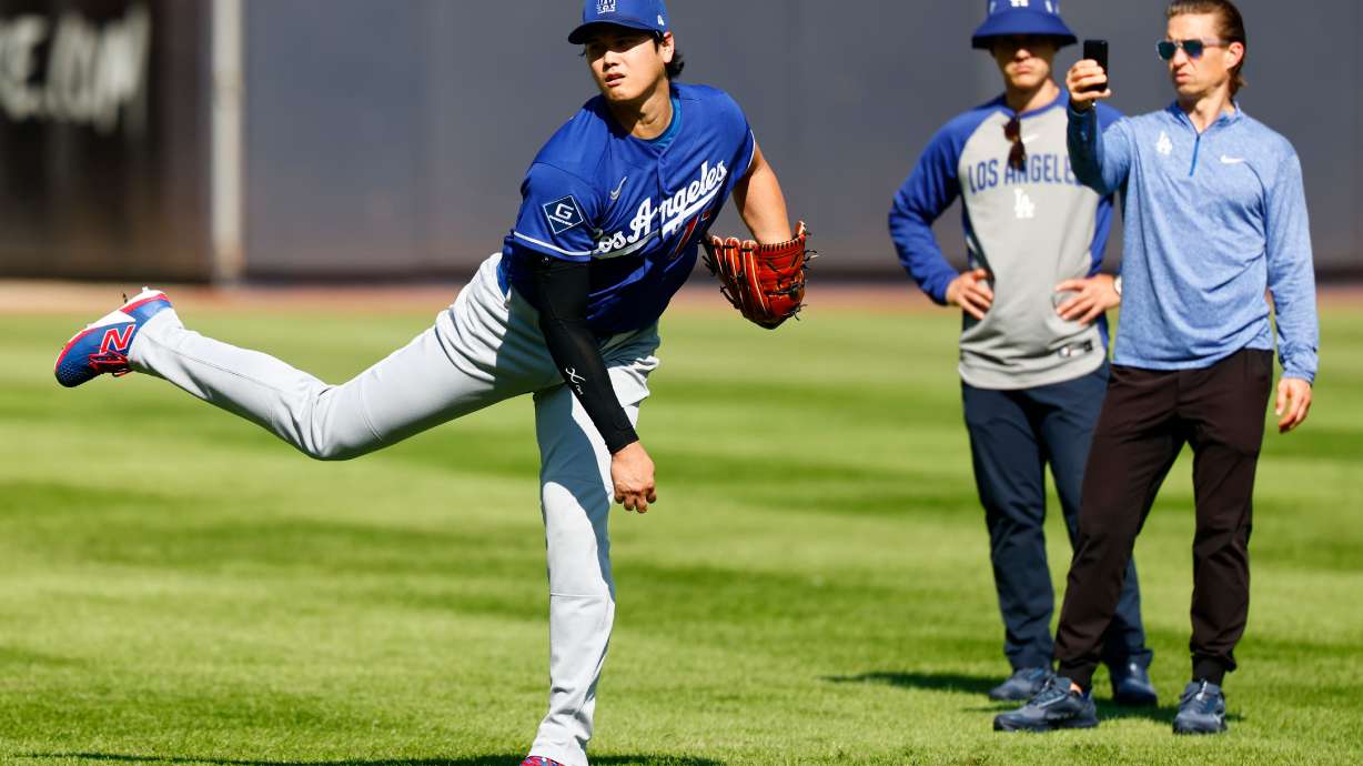 Los Angeles Dodgers' Shohei Ohtani, left, throws in the outfield before the second game of a baseball doubleheader against the New York Yankees, Sunday, July 19, 2026, in New York.