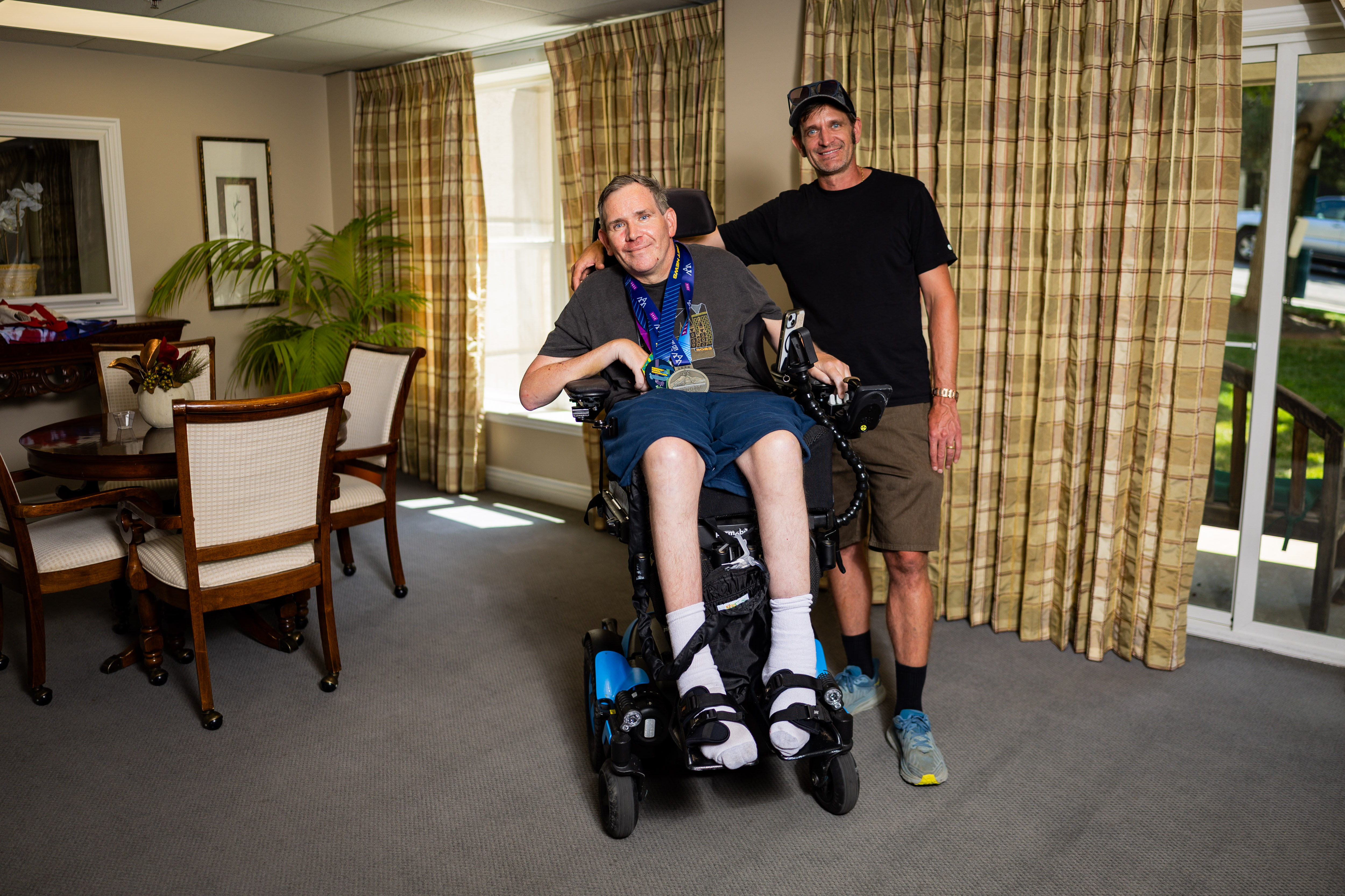 Danny Connolly and his brother Brian Connolly, who has MS, in a common area at Brian's condominium in Salt Lake City on Tuesday. The Connollys ran in Friday's Deseret News Marathon.