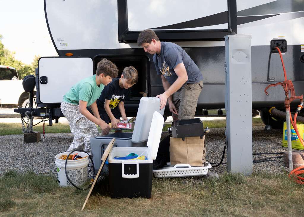 Jett Rink and his sons, Johnathan, 9, and Jett, 11, of Baton Rouge return caping equipment to their camper at the KOA in Perry on Thursday, June 25. The family is on their way to Yellowstone National Park.