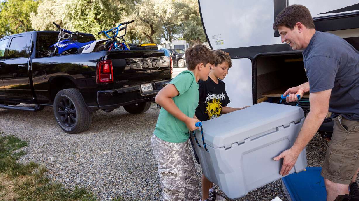 Jett Rink and his sons, Johnathan, 9, and Jett, 11, of Baton Rouge return caping equipment to their camper at the KOA in Perry on Thursday, June 25. The family is on their way to Yellowstone National Park.