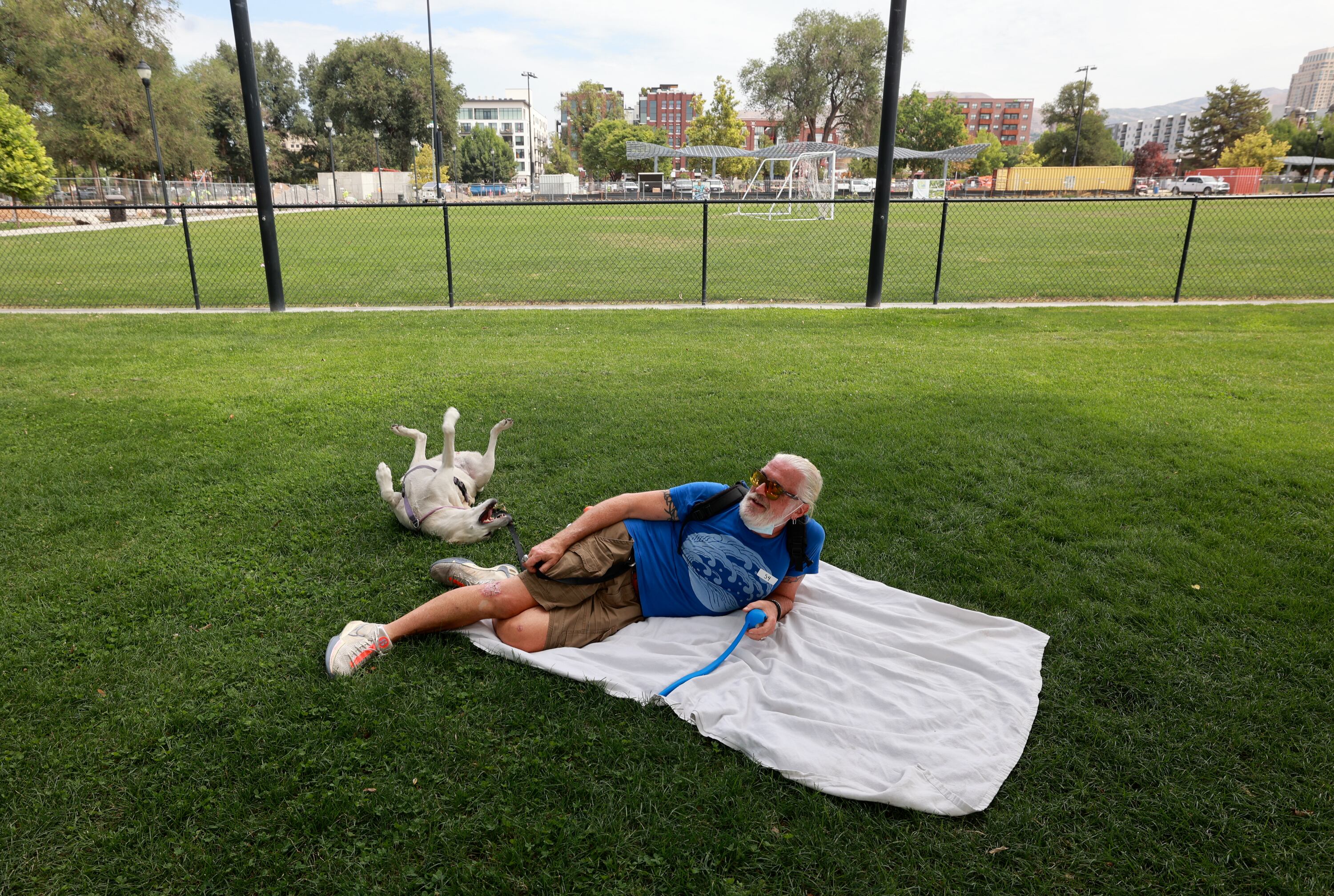 Carl Brennan relaxes with his dog June Lawrence at Pioneer Park in Salt Lake City on July 15.