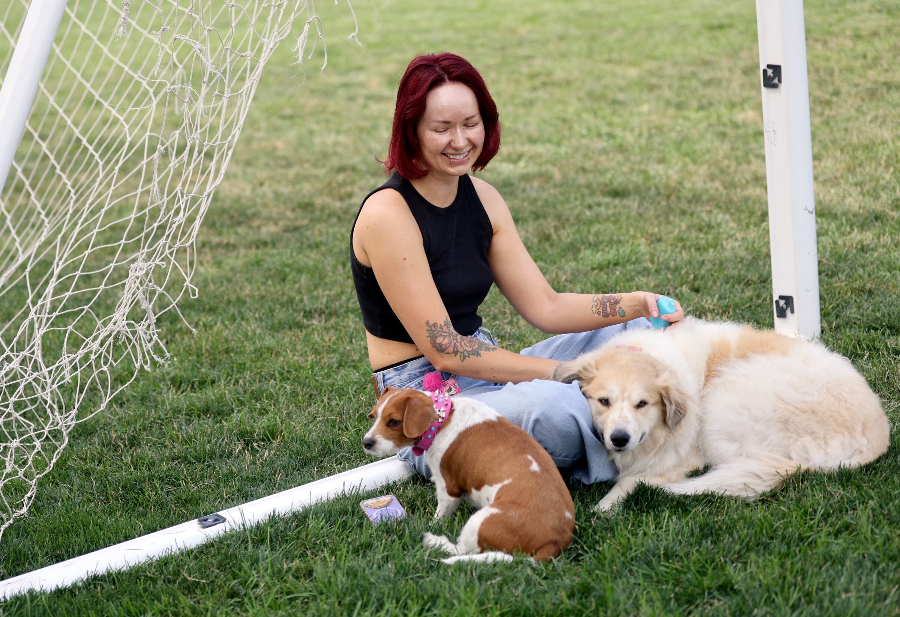 Anna Shmynets sits with her dogs Napkin, left, and Trixie at Pioneer Park in Salt Lake City on July 15.