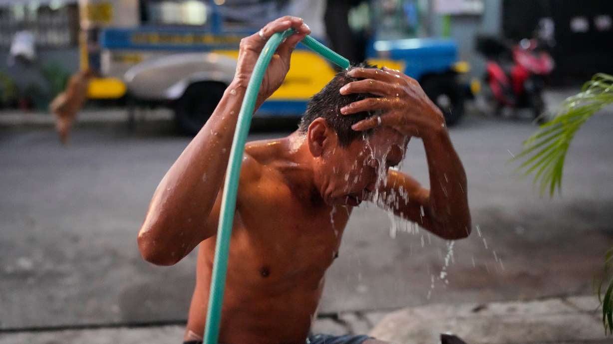 Jeepney driver Edgar Funelas bathes outside along a street near the jeepney where he and his 10-year-old daughter live in Quezon City, Philippines, on April 10.