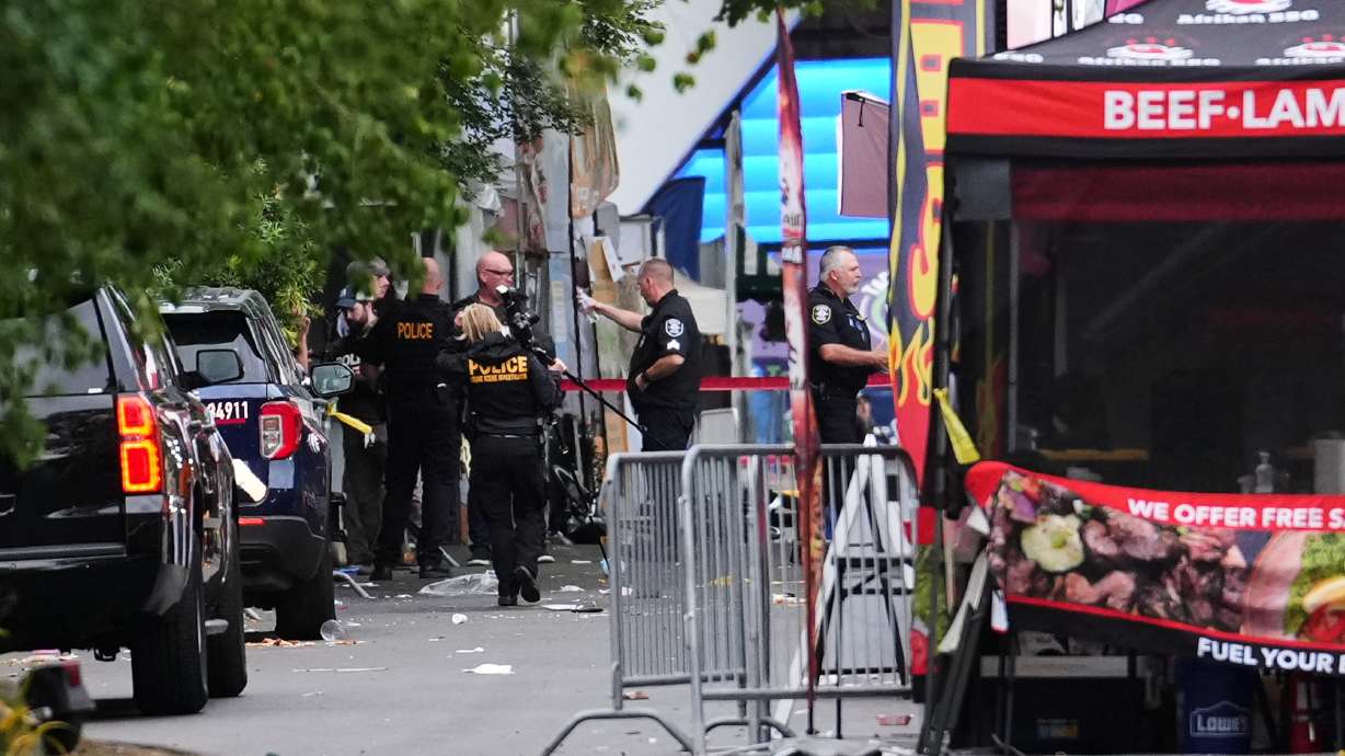 A crime scene photographer arrives as law enforcement examines the scene following a shooting at Seattle Center during the Bite of Seattle food festival Sunday in Seattle.