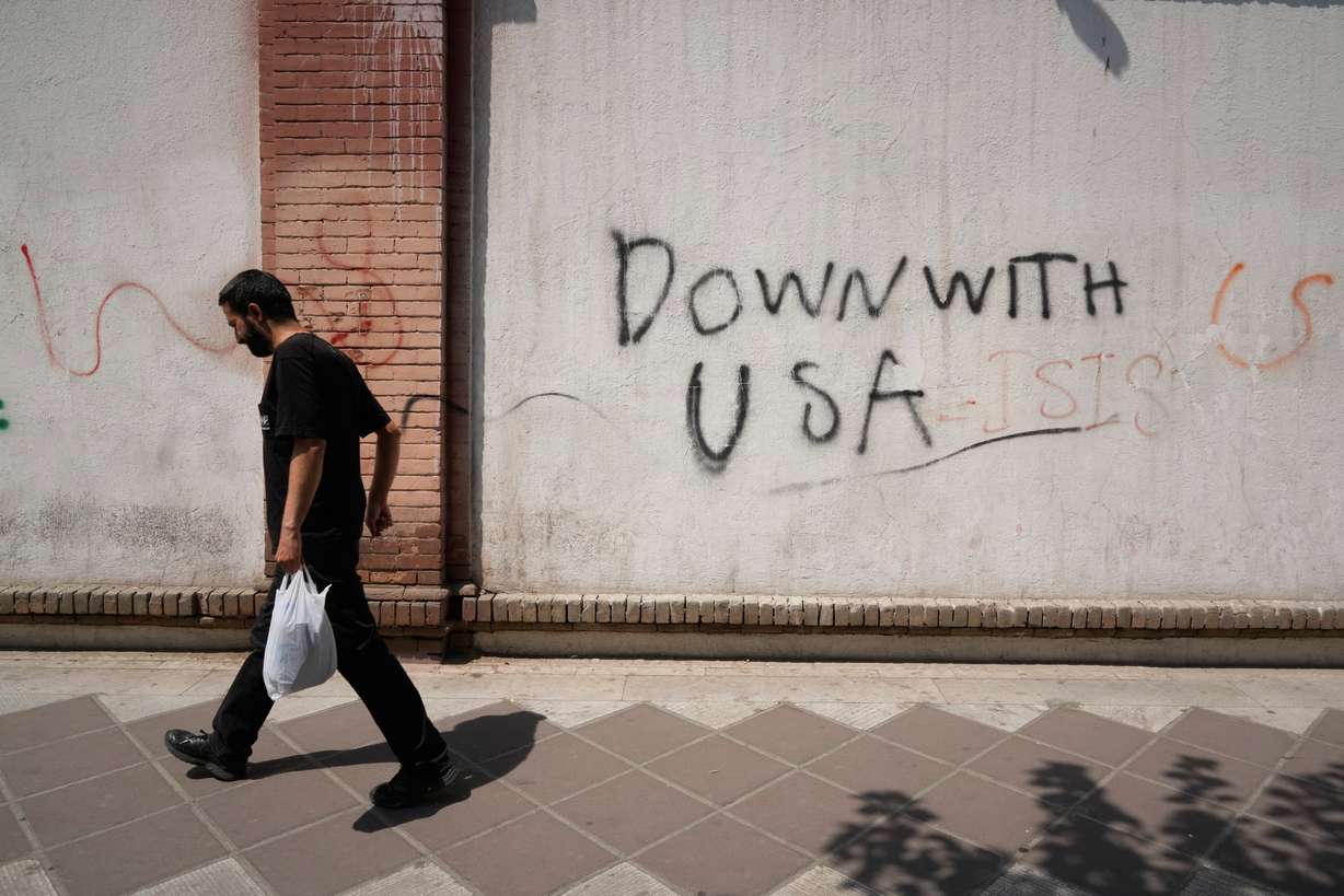A man walks past anti-U.S. graffiti on the wall of the British Embassy in Tehran, Iran, Monday. President Donald Trump and Israeli Prime Minister Benjamin Netanyahu are meeting on Tuesday in their first talks since launching the Iran war.