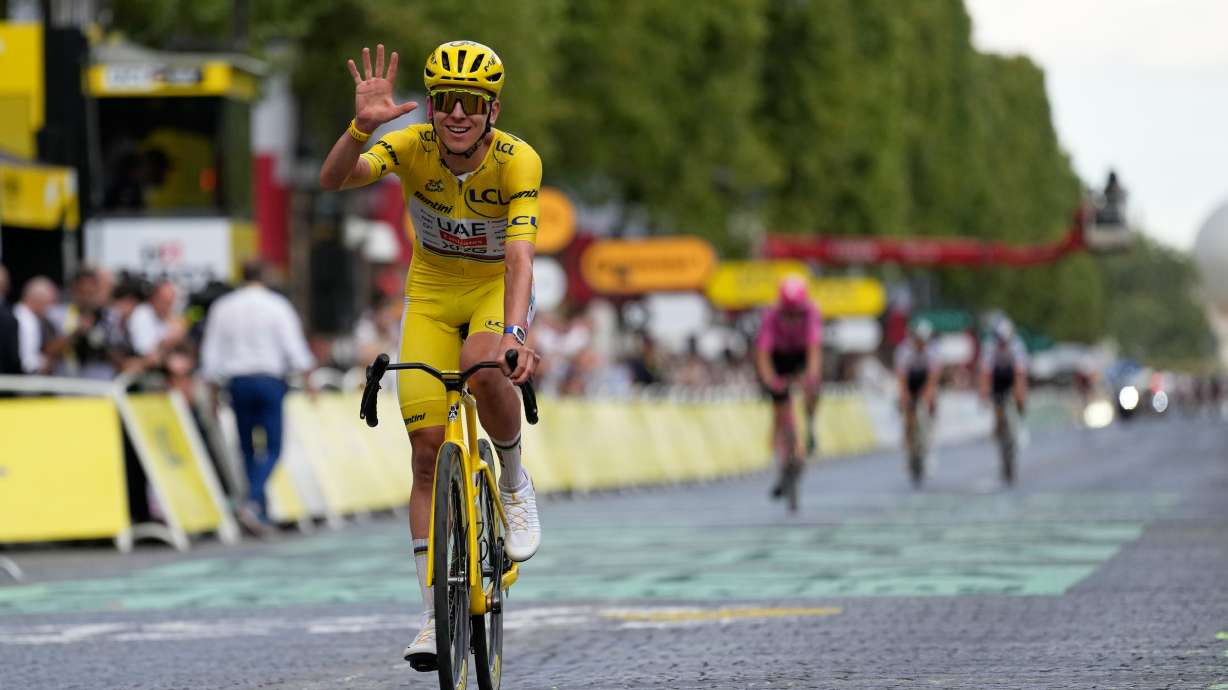 Slovenia's Tadej Pogacar, wearing the overall leader's yellow jersey, celebrates as he crosses the finish line of the last stage of the Tour de France cycling race with start and finish in Paris, Sunday, July 26, 2026.