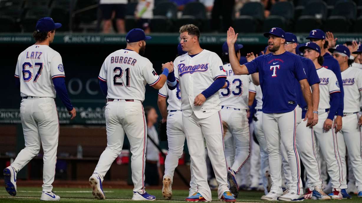 Texas Rangers' Jacob Latz (67), Jake Burger (21), Joc Pederson, center, Nathan Eovaldi, right and the rest of the team celebrate their win against the Seattle Mariners in a baseball game in Arlington, Texas, Monday, July 27, 2026.