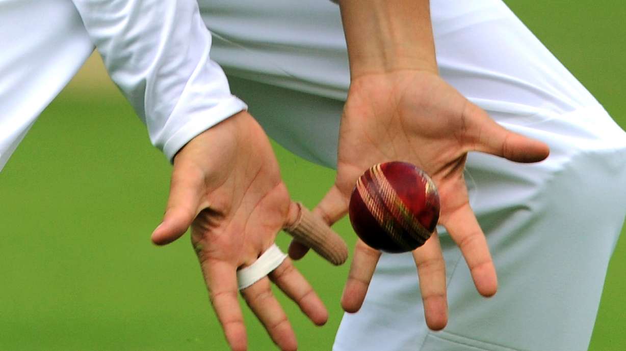 FILE - View of cricketer's hands catching a cricket ball during day four of the first Ashes Test cricket match, in Cardiff, Wales, Saturday, July 11, 2015.