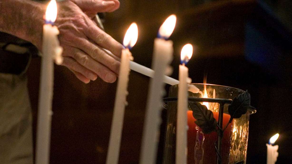 Vaughn Lovejoy lights a candle during the second annual Day of Remembrance for Utah Downwinders at the Skaggs Memorial Chapel, First Baptist Church of Salt Lake City, on Jan. 27, 2013. A clinic is hosting free public meetings across the Beehive State to provide information about the recently expanded law and help individuals determine if they or a loved one could qualify for compensation.