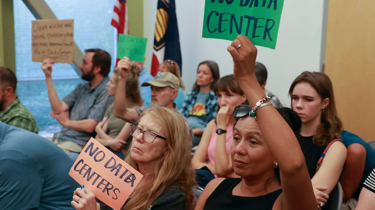 Lorena Bush holds a NO DATA CENTER sign during a public hearing in Salt Lake City on Monday. Opponents are concerned a permit would authorize the discharge of up to 260,000 gallons per day of concentrated industrial brine.