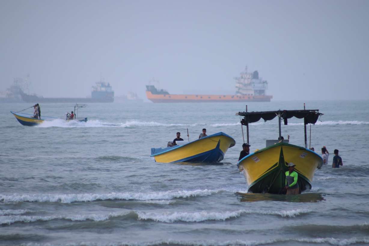Small boats line the shore as cargo ships and other commercial vessels appear anchored in the Strait of Hormuz off Bandar Abbas, Iran, on Monday.