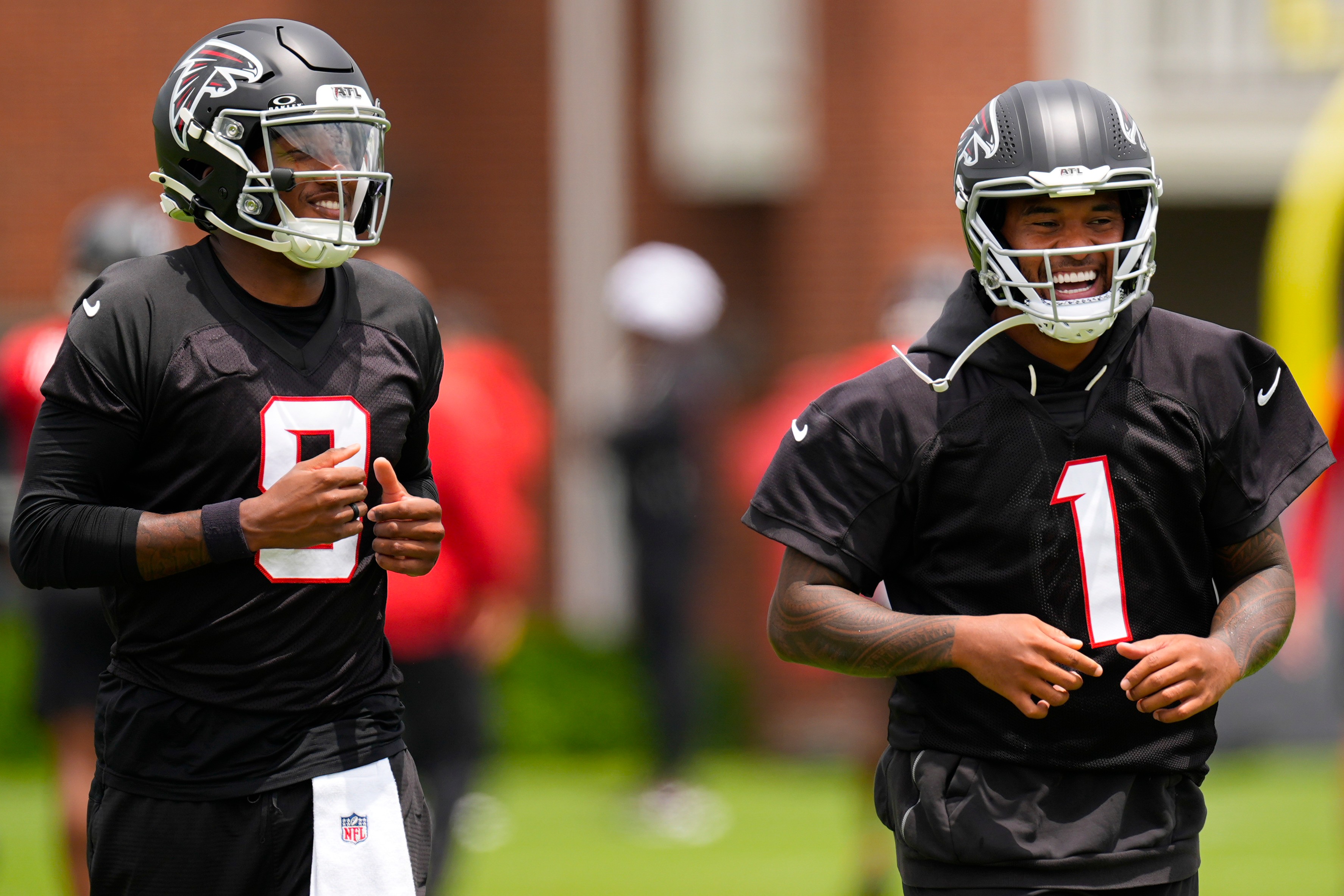 FILE - Atlanta Falcons quarterback's Michael Penix Jr. and Tua Tagovailoa (1) move during an NFL football practice, Wednesday, May 27, 2026, in Flowery Branch, Ga. 