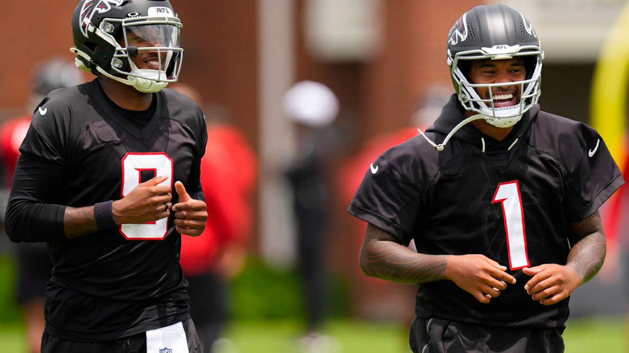 FILE - Atlanta Falcons quarterback's Michael Penix Jr. and Tua Tagovailoa (1) move during an NFL football practice, Wednesday, May 27, 2026, in Flowery Branch, Ga.
