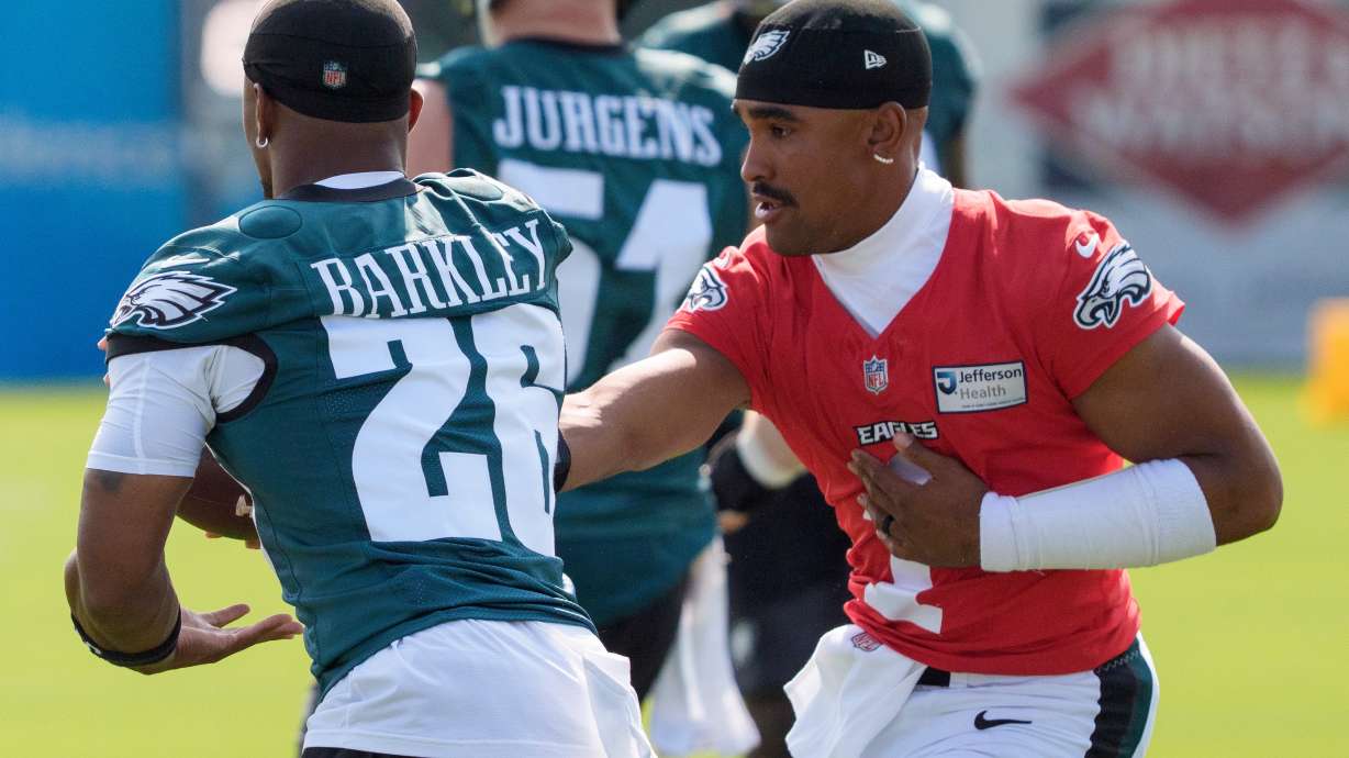 Philadelphia Eagles quarterback Jalen Hurts (1) hands the ball off to running back Saquon Barkley (26) during practice at the team's NFL football training camp in Philadelphia, Wednesday, July 29, 2026.
