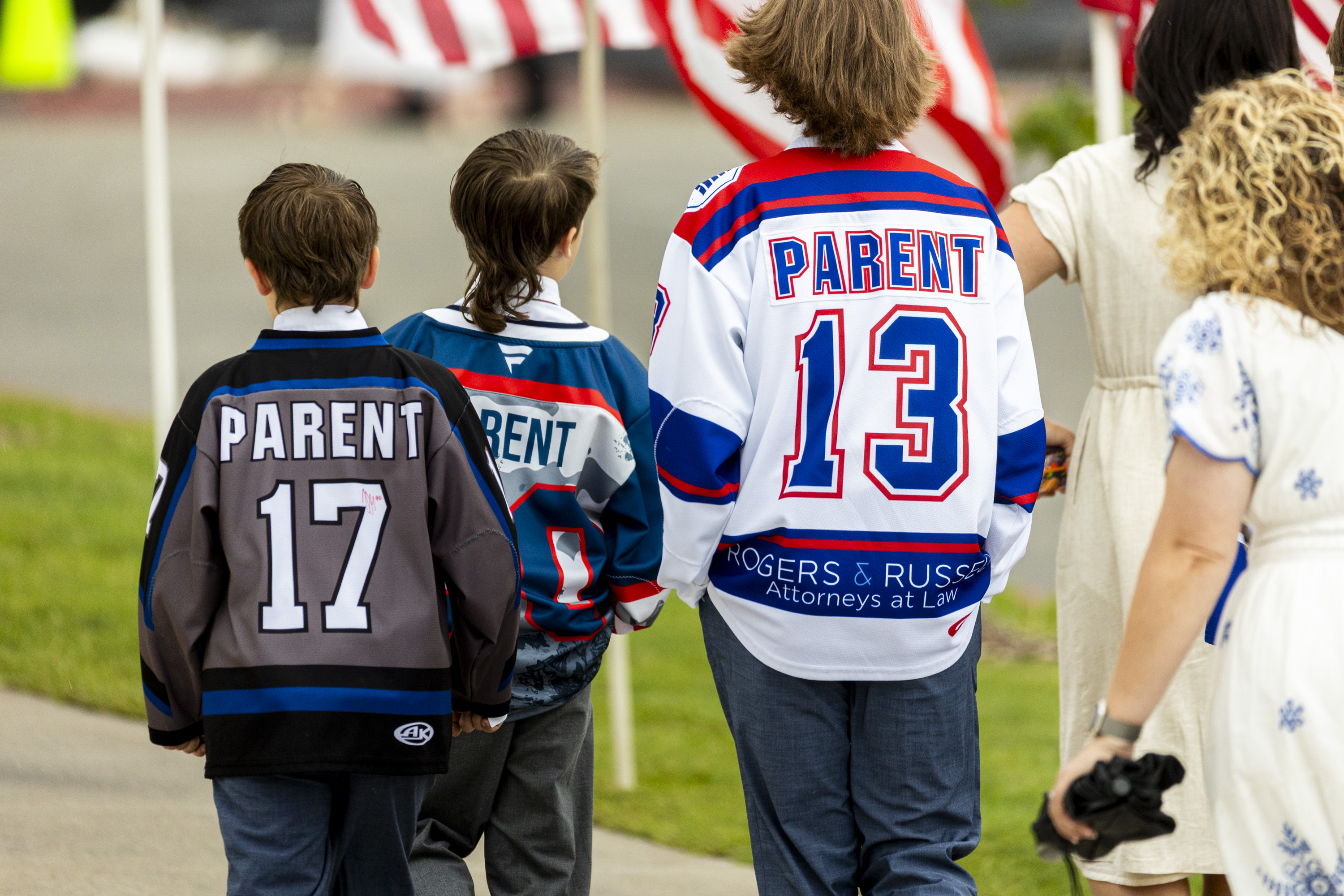 Kids sport hockey jerseys as they make their way toward the entrance with their families before the Long family funeral held at the UCCU Center in Orem on Wednesday.