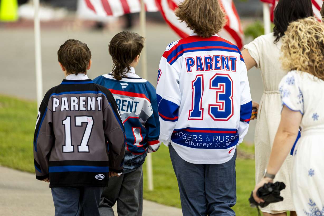 Kids sport hockey jerseys as they make their way toward the entrance with their families before the Long family funeral held at the UCCU Center in Orem on Wednesday.