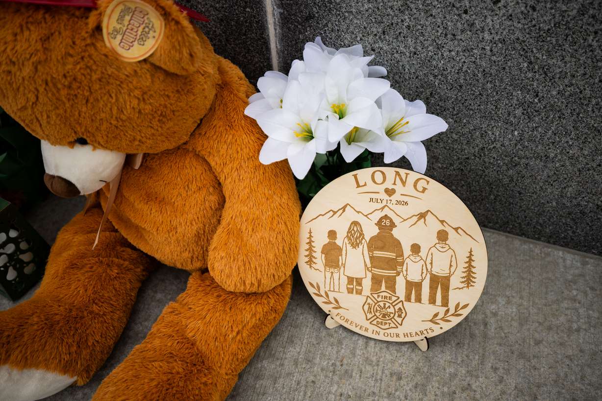 A memorial with flowers, stuffed animals and photos for Provo Fire Capt. Spencer Long and four members of his family who were killed in a flash flood during a weekend camping and hiking trip in Wayne County, outside of City Hall in Provo on July 22.