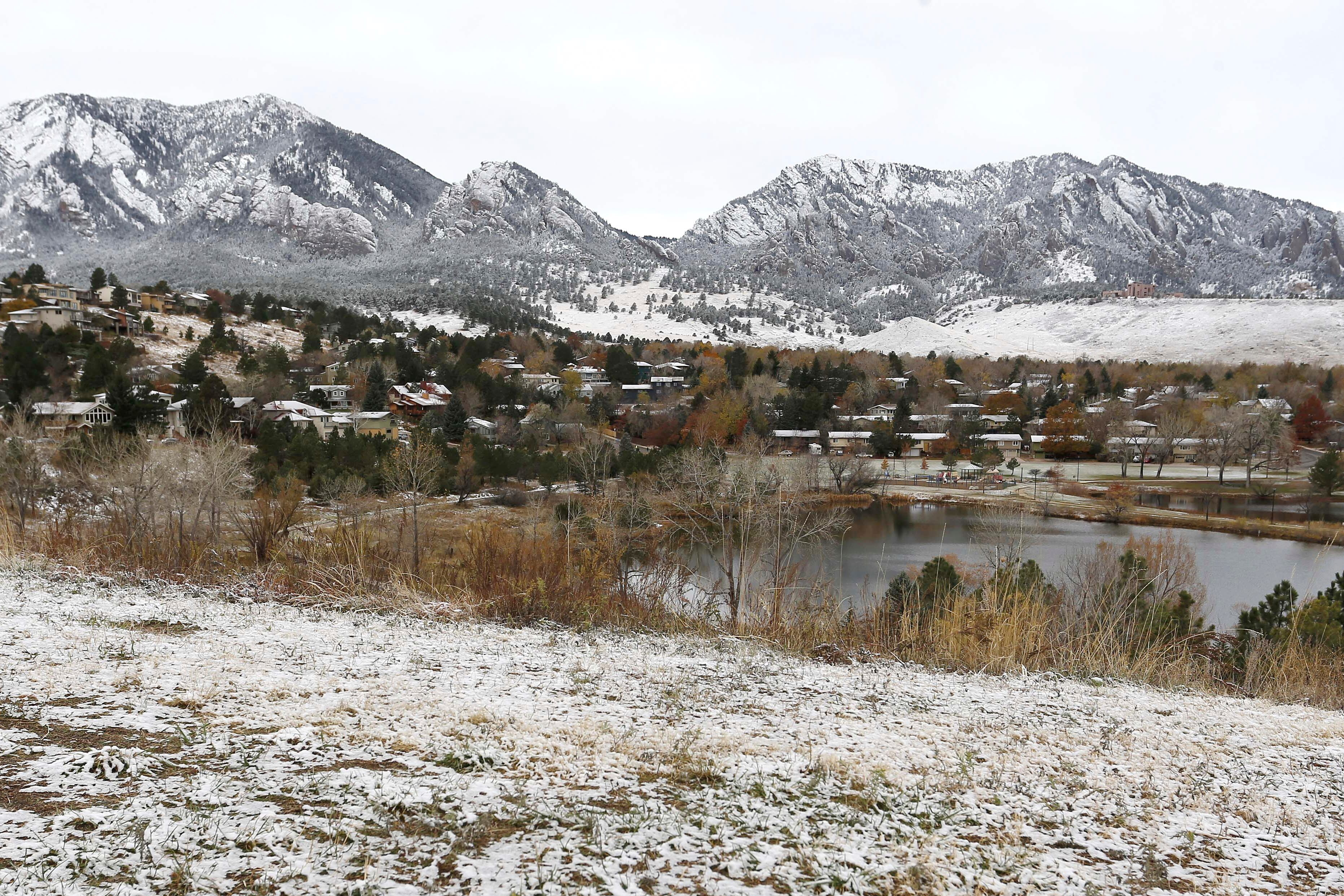 The Flatirons mountain formation lies dusted white after a night of light snowfall, in Boulder, Colo., on Nov. 17, 2015.