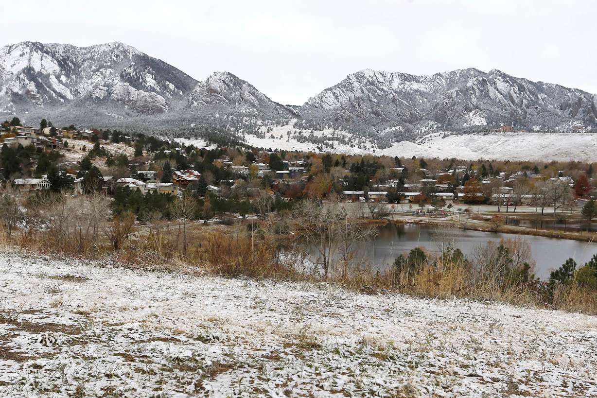 The Flatirons mountain formation lies dusted white after a night of light snowfall, in Boulder, Colo., on Nov. 17, 2015.