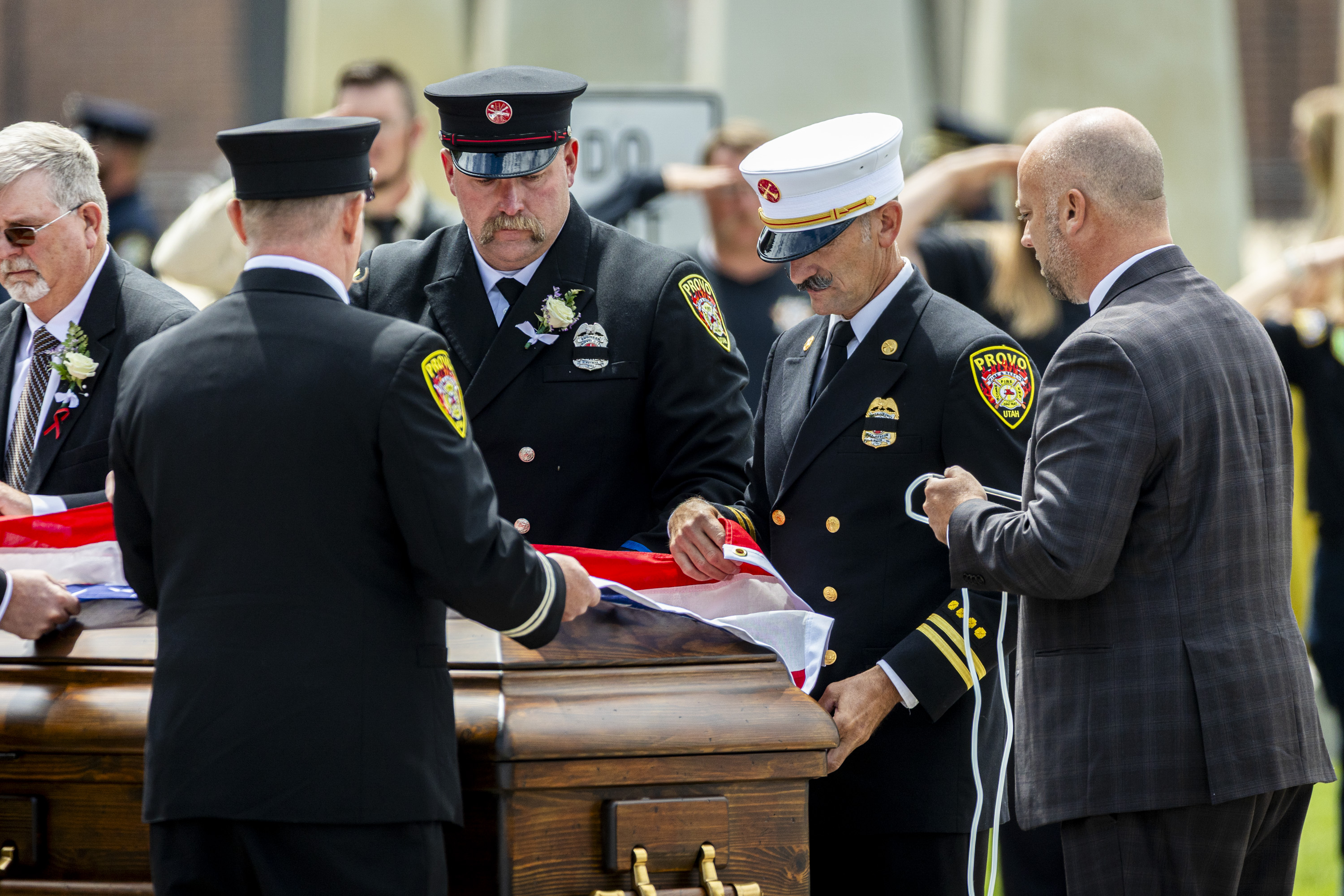 Members of the Provo Fire Department drape an American flag on the casket of Provo Fire Capt. Spencer Long after his family’s funeral at the UCCU Center in Orem on Wednesday.