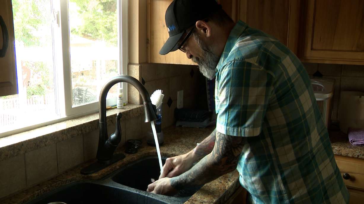 Brandon Peterson cleans his temporary set of dentures. His dentist retired, and the office he was directed to refuses to take him, even though both offices were part of the same network.