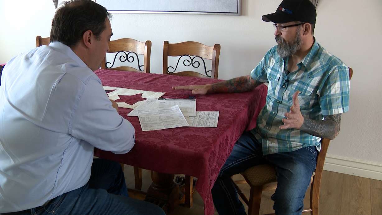 Brandon Peterson shows KSL's Matt Gephardt paperwork from Affordable Dentures and Implants regarding his dentures.
