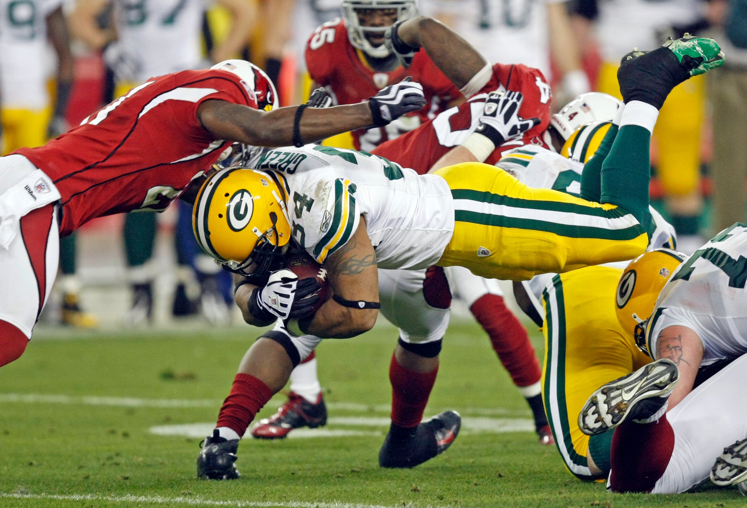 FILE - Green Bay Packers' Ahman Green (34) dives for a first down in front of Arizona Cardinals' Antrel Rolle (21) during the second half of an NFL wild-card playoff football game, Jan. 10, 2010, in Glendale, Ariz. 