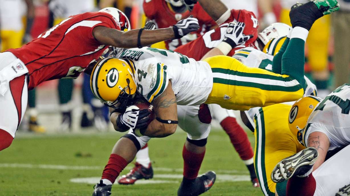 FILE - Green Bay Packers' Ahman Green (34) dives for a first down in front of Arizona Cardinals' Antrel Rolle (21) during the second half of an NFL wild-card playoff football game, Jan. 10, 2010, in Glendale, Ariz.