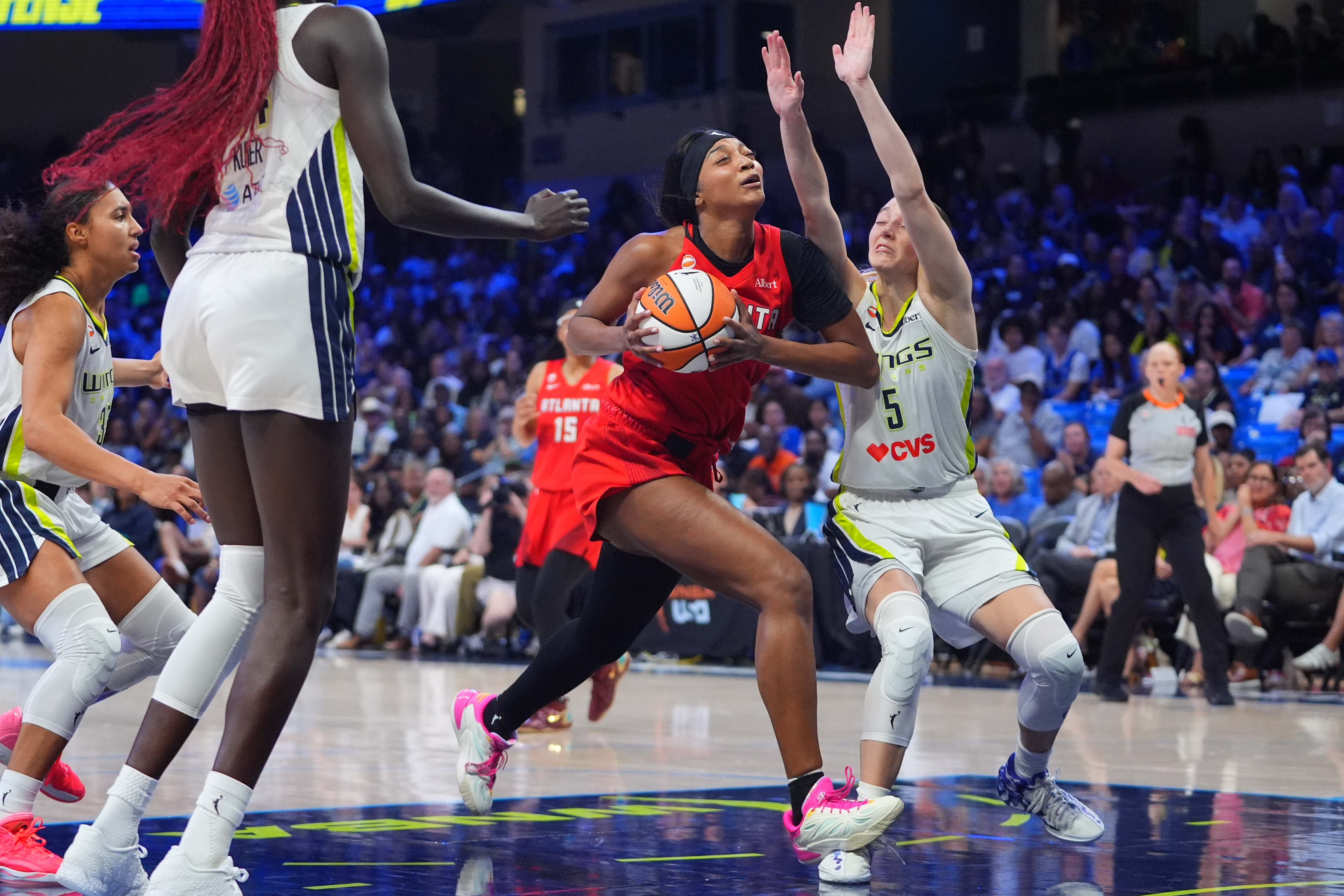 Atlanta Dream forward Angel Reese, center, drives against Dallas Wings guard Paige Bueckers (5) during the second half of a WNBA basketball game in Arlington, Texas, Wednesday, July 29, 2026. 