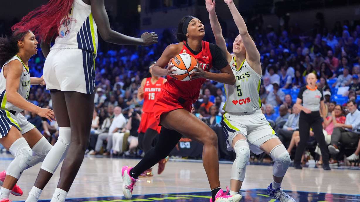Atlanta Dream forward Angel Reese, center, drives against Dallas Wings guard Paige Bueckers (5) during the second half of a WNBA basketball game in Arlington, Texas, Wednesday, July 29, 2026.