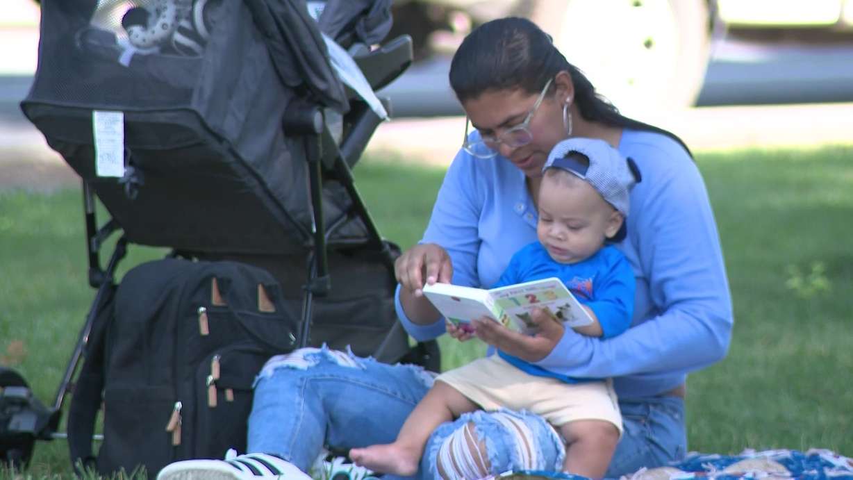 A mother is pictured reading to her child at an event focused on building early literacy in South Salt Lake on Thursday.