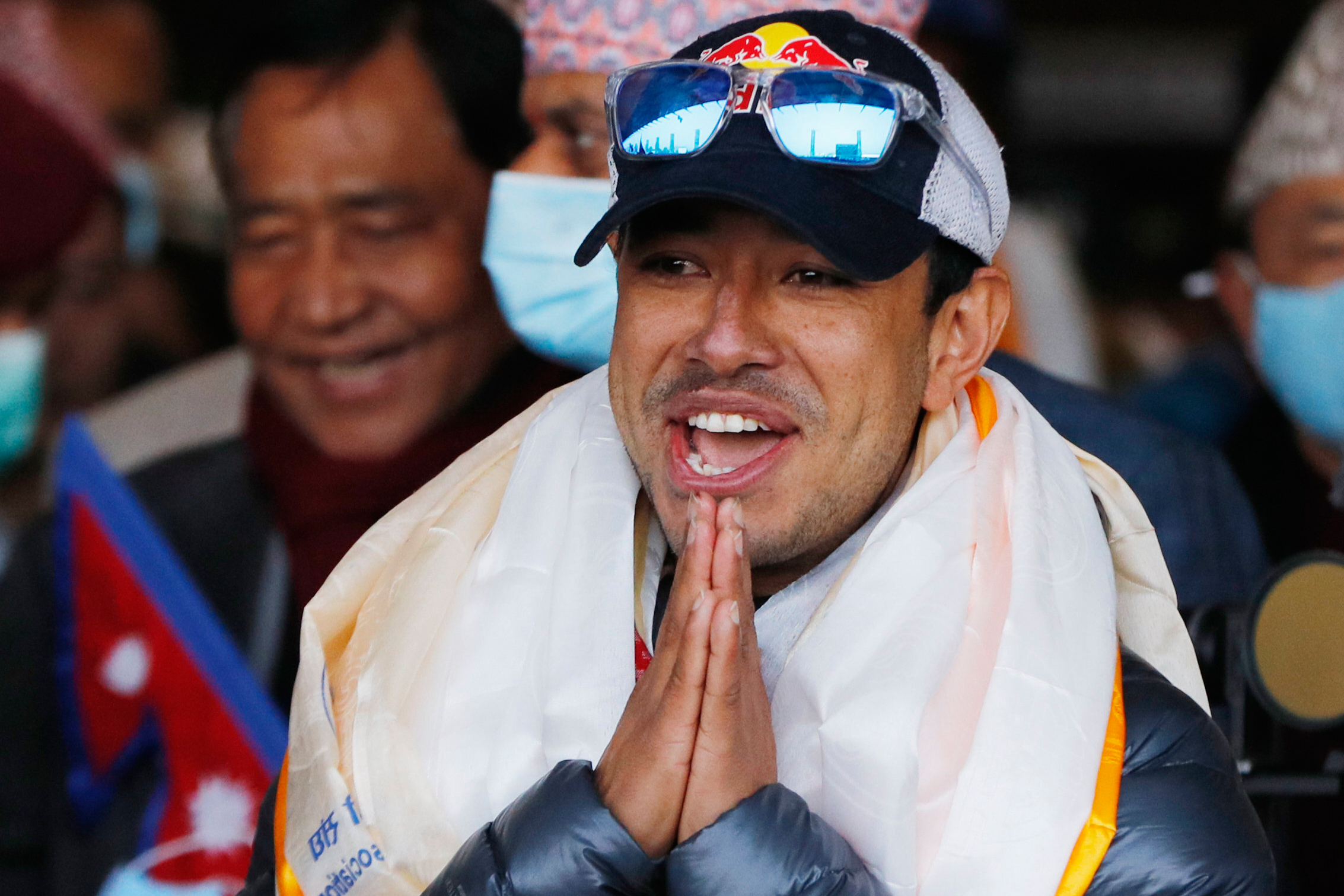 FILE - Nirmal Purja, one of the team member of the all-Nepalese mountaineering team that became the first to scale Mount K2 in winter, gestures as the team arrives at Tribhuwan International airport in Kathmandu, Nepal, Jan. 26, 2021. 