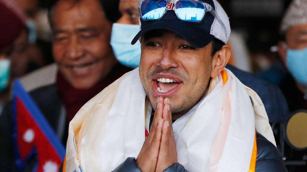FILE - Nirmal Purja, one of the team member of the all-Nepalese mountaineering team that became the first to scale Mount K2 in winter, gestures as the team arrives at Tribhuwan International airport in Kathmandu, Nepal, Jan. 26, 2021.