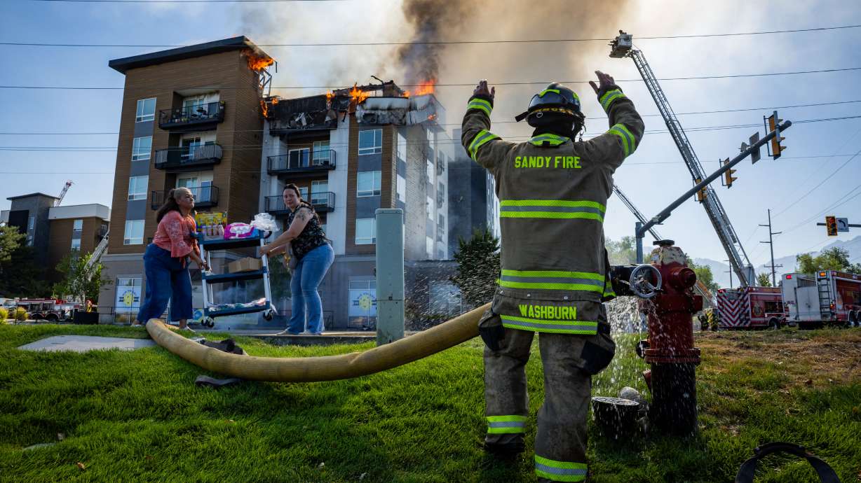 Tenants of the Midvale apartment complex damaged in a blaze in late July are pressing for help and answers. The July 31 photo shows a member of the Sandy Fire Department at the blaze at 942 E. North Union Ave.