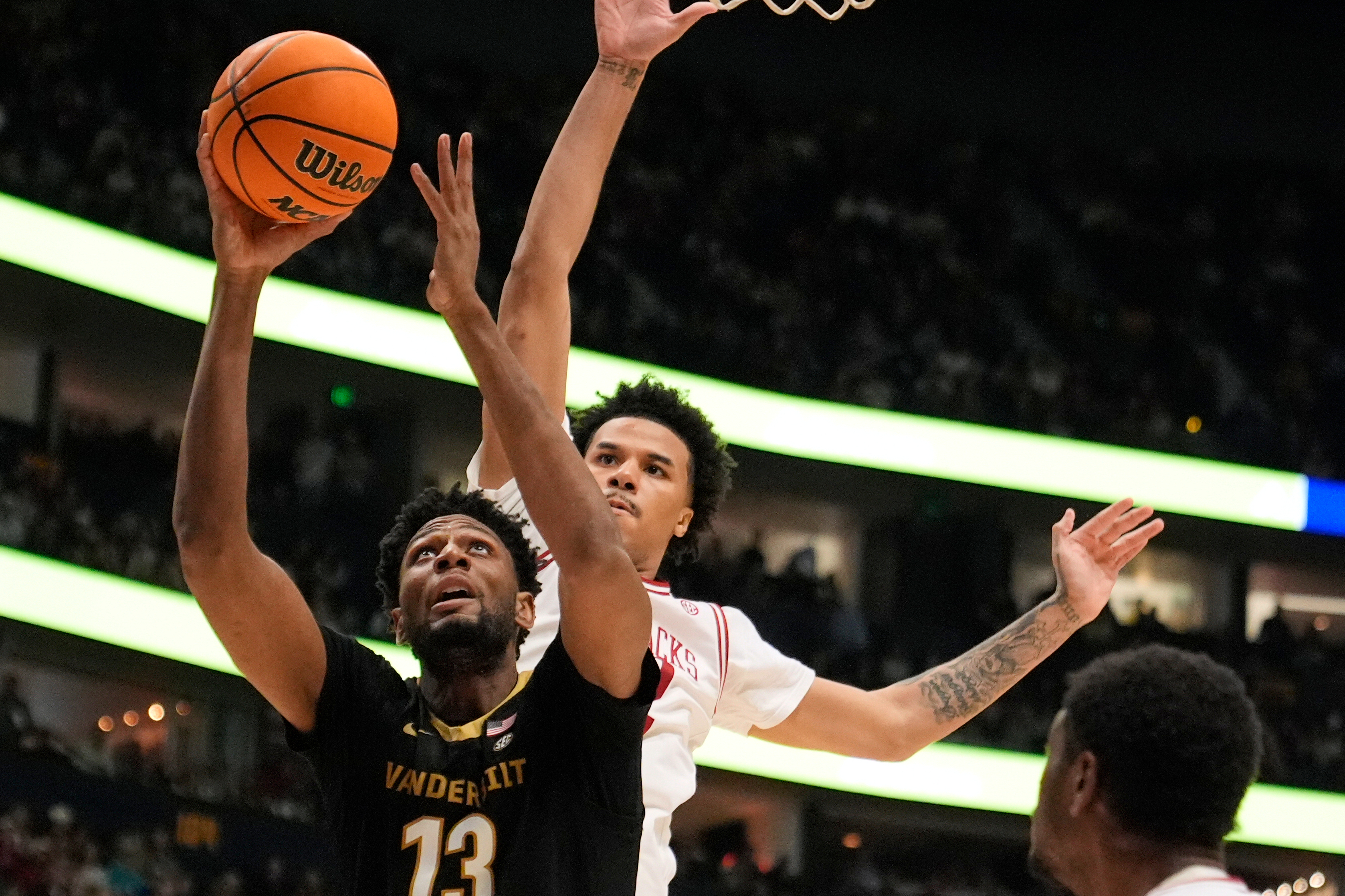 FILE - Vanderbilt forward Jalen Washington (13) shoots the ball past Arkansas forward Malique Ewin, right, during the first half of an NCAA college basketball game in the final of the Southeastern Conference tournament March 15, 2026, in Nashville, Tenn. 