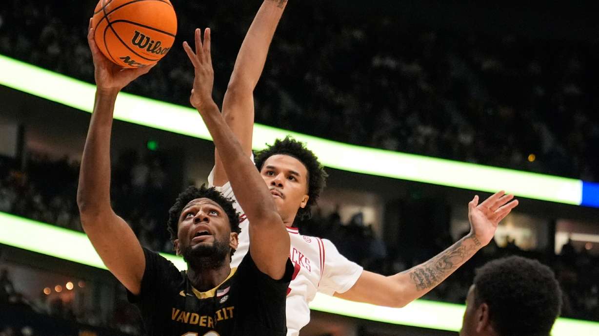 FILE - Vanderbilt forward Jalen Washington (13) shoots the ball past Arkansas forward Malique Ewin, right, during the first half of an NCAA college basketball game in the final of the Southeastern Conference tournament March 15, 2026, in Nashville, Tenn.
