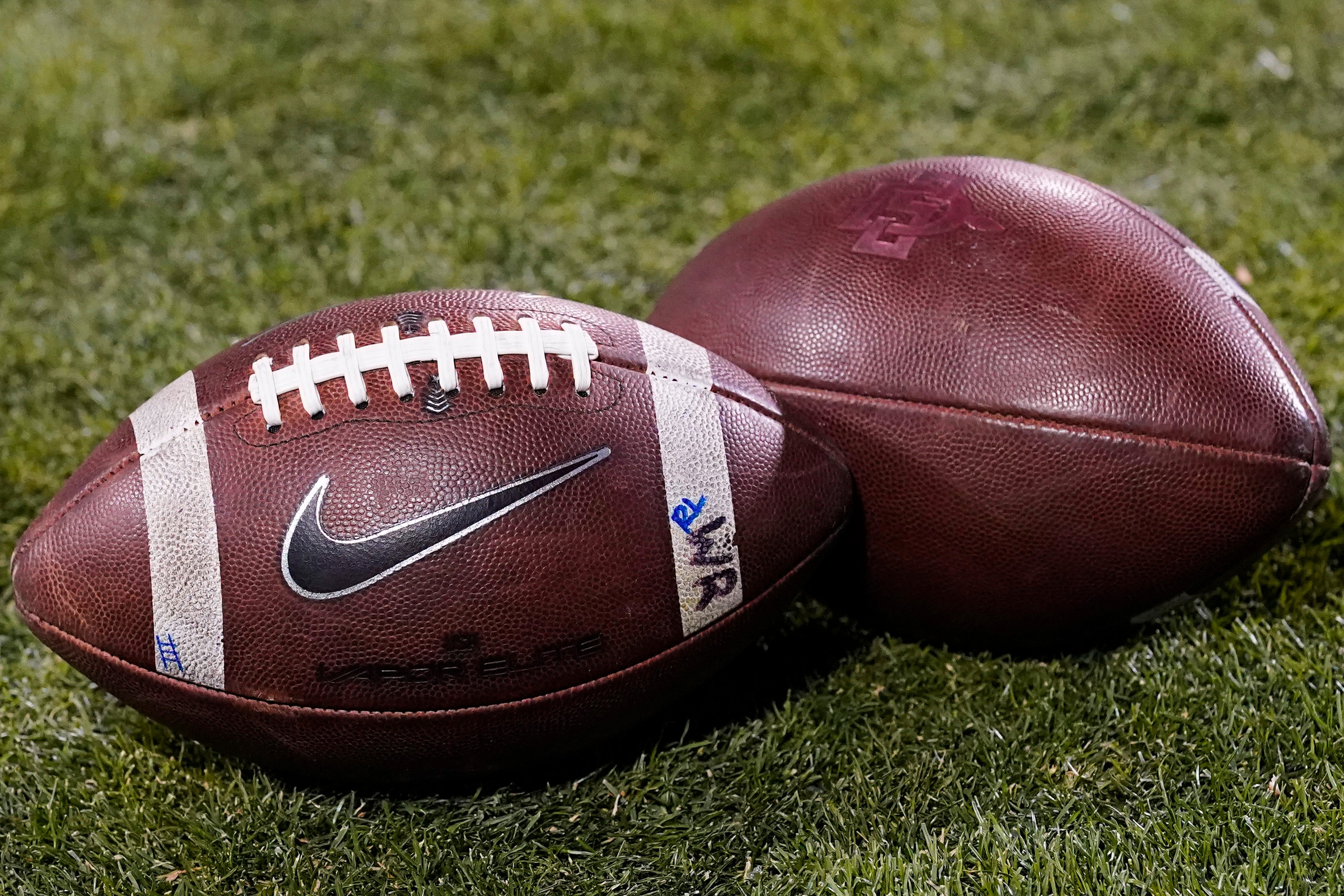 FILE - Footballs rest on the field in the second half of an NCAA college football game Nov. 28, 2020, in Boulder, Colo. 