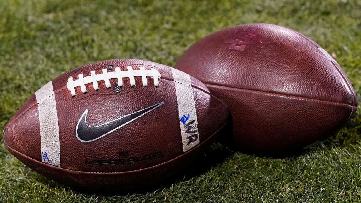 FILE - Footballs rest on the field in the second half of an NCAA college football game Nov. 28, 2020, in Boulder, Colo.