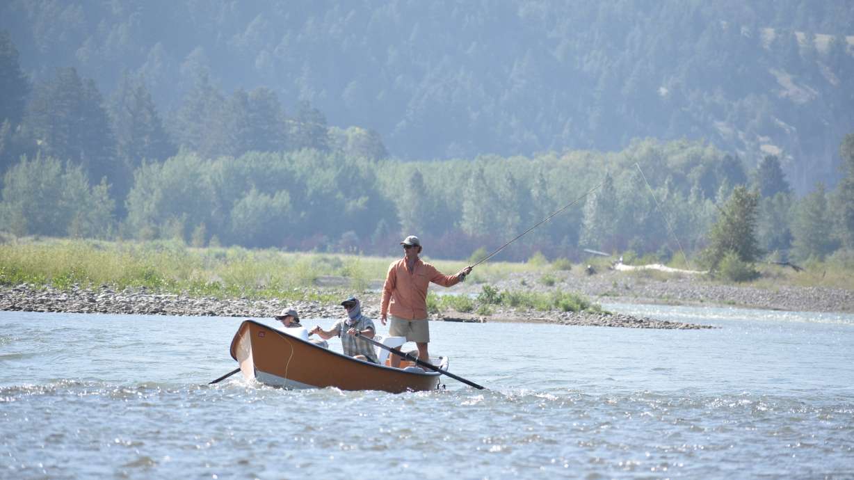 A drift boat with people fly fishing floats down the Yellowstone River, Friday near Livingston, Montana.