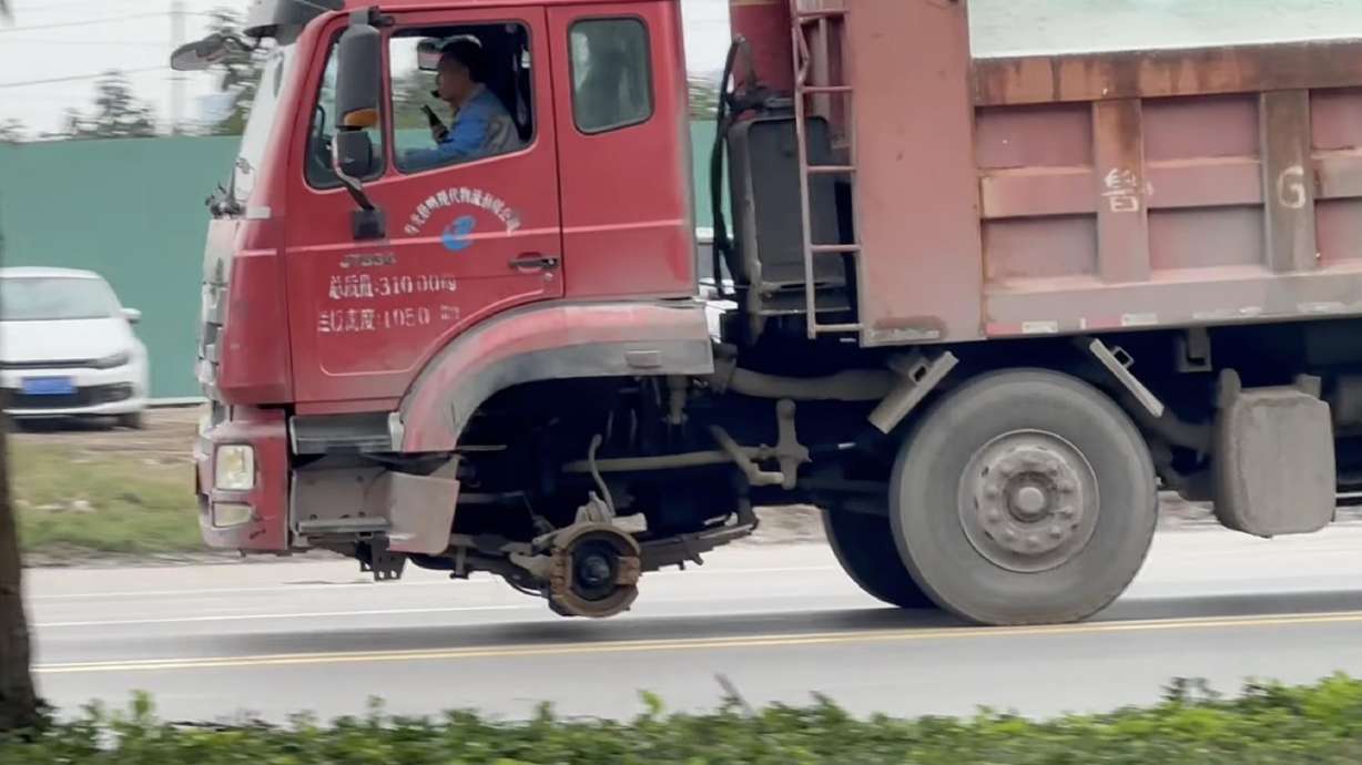 A video shows an 8x4 dump truck traveling on a public road despite missing two front steering wheels. Even without the wheels, the truck appeared to remain stable and level, with no visible leaning.