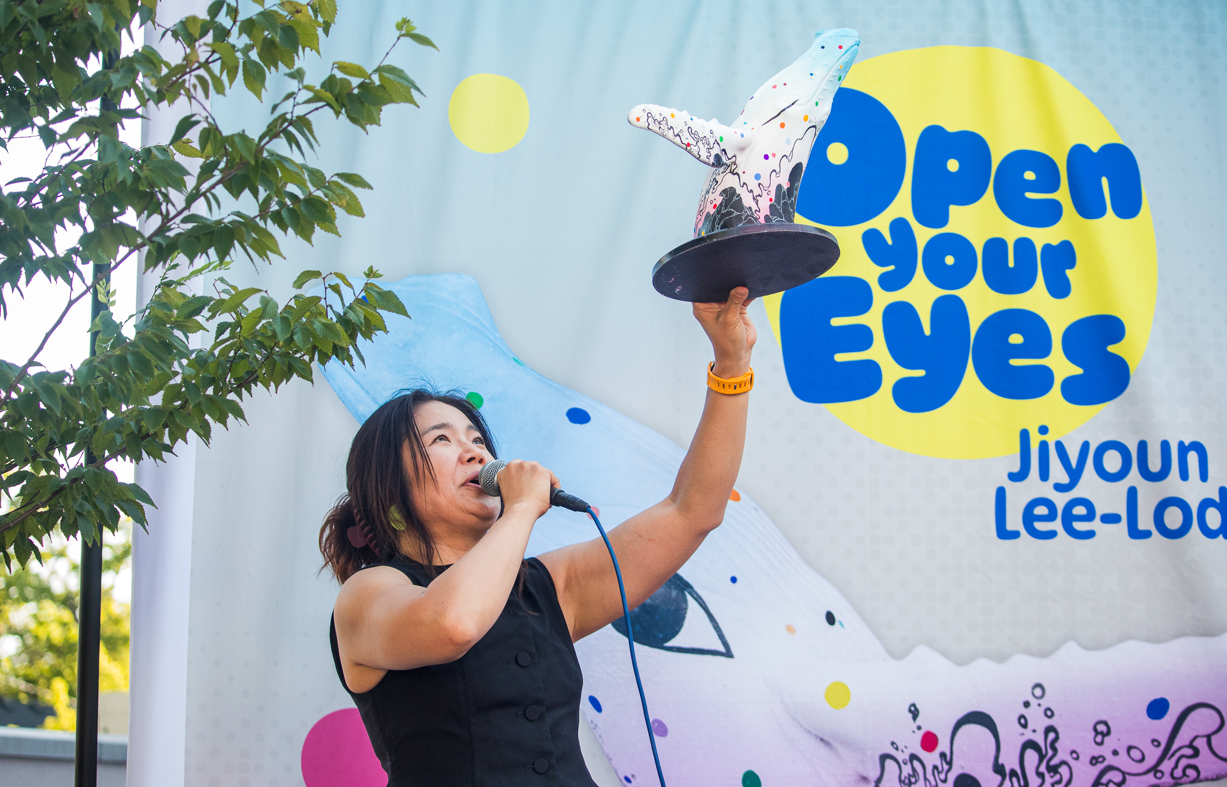 Salt Lake-based artist Jiyoun Lee-Lodge holds up a model of her mural "Open Your Eyes" during an unveiling of the new mural for "Out of the Blue" in Salt Lake City on Saturday. The mural will be painted on the city's whale sculpture in the coming weeks.