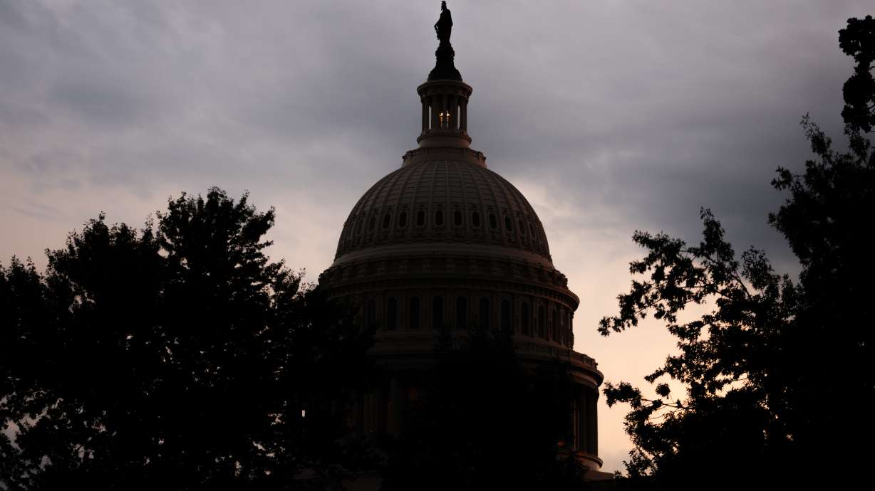 The sun sets behind the U.S. Capitol on Tuesday in Washington. Key senators unveiled a short-term spending bill that would keep federal agencies funded past the midterm elections and into early December as they look to avoid a government shutdown.