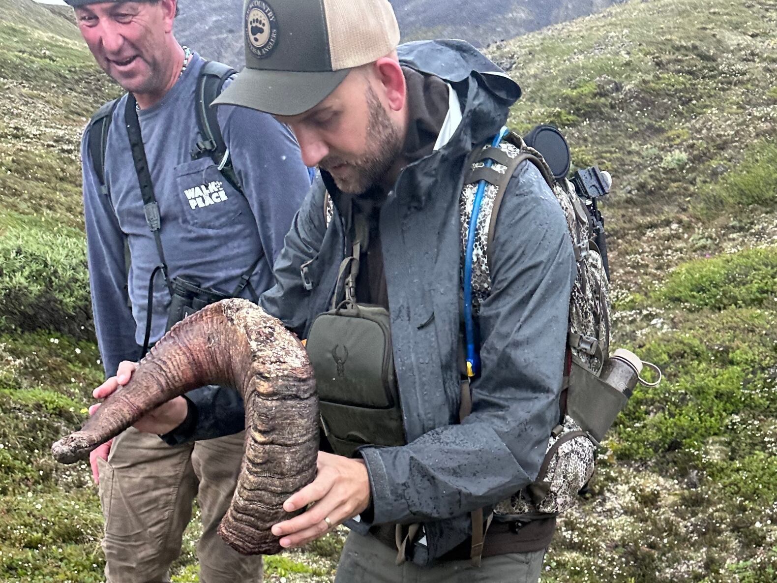 Kaden McArthur, a Utah native and current lobbyist with Trout Unlimited, holds the horn of a dall ram whose rings showed it was at least 10–12 years old while Jeffrey “Country” Gillespie stands next him on June 30.