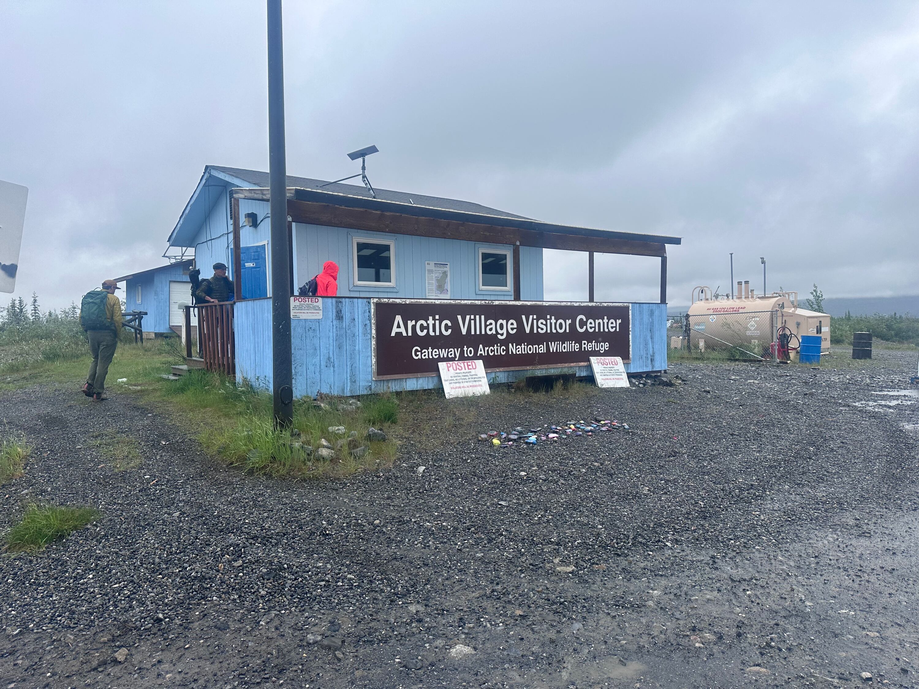 A group of journalists approach the one-room visitor center of Arctic Village, Alaska, a town of about 200 people, on June 29, during a frigid, summer rainstorm for a layover prior to a bush flight into the Arctic National Wildlife Refuge.